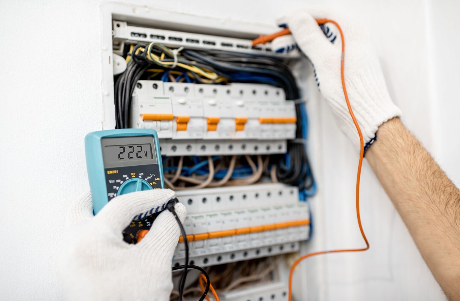 Técnico de Ednoclima usando un multímetro para realizar mediciones y diagnóstico de un fallo en una instalación eléctrica industrial en Tarancón